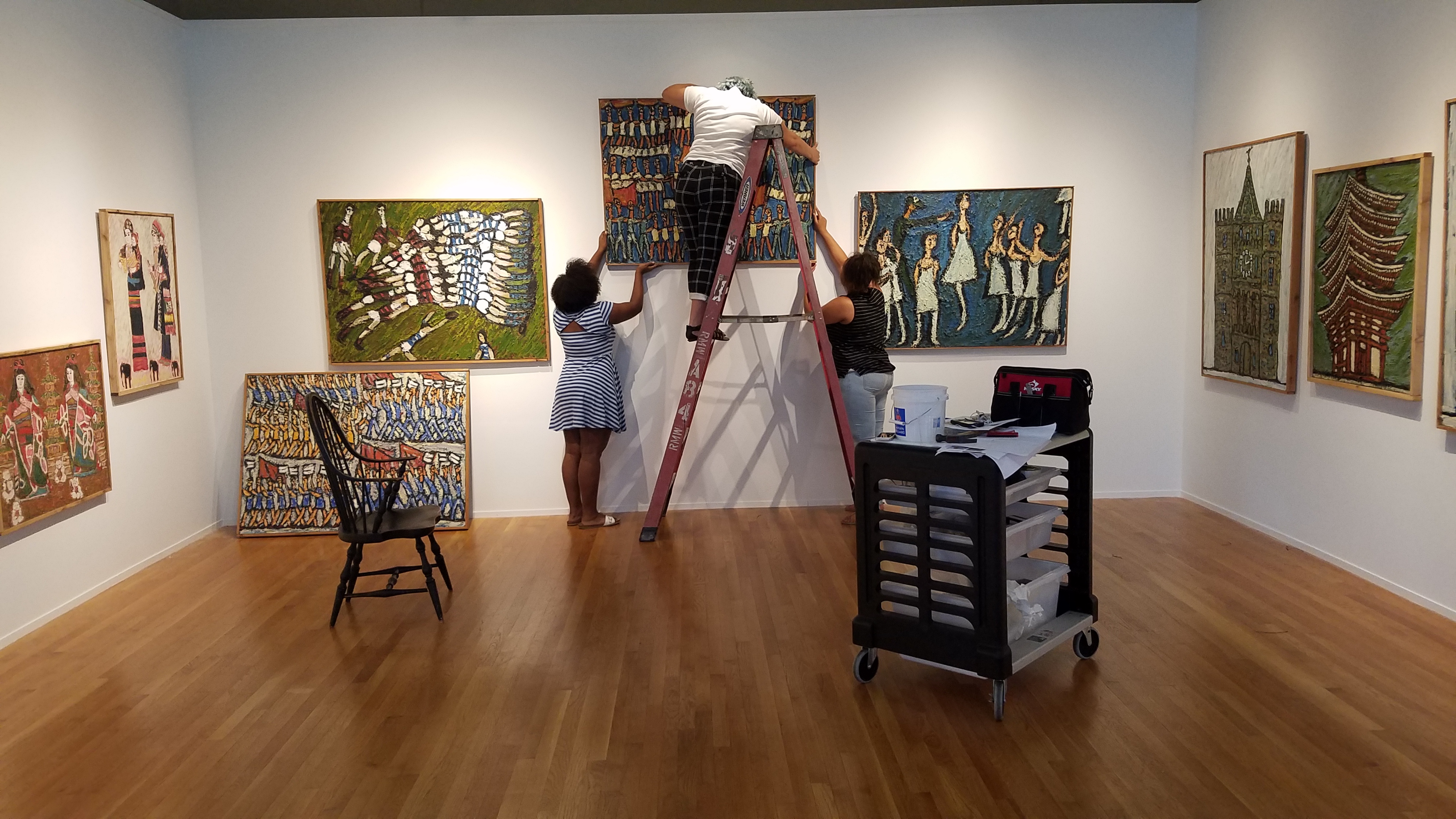 students hanging art in gallery 